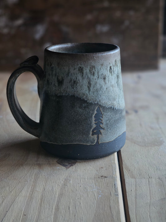 Moody Forest mug featuring resisted pine trees in green and dark gray glaze over black clay- northern Idaho pottery