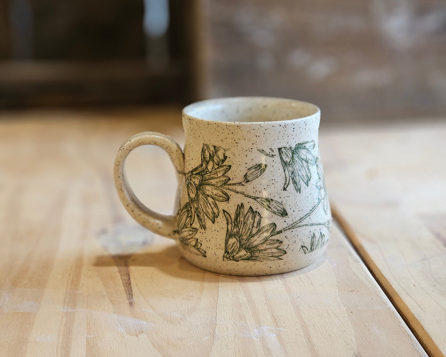 Full bellied wheel thrown pottery mug in a green daisy design - made in Idaho