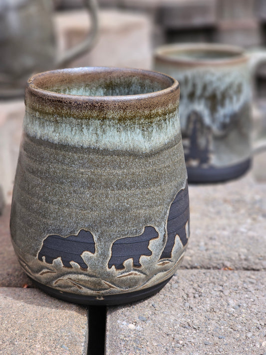 Ceramic cup with bear designs on a stone surface