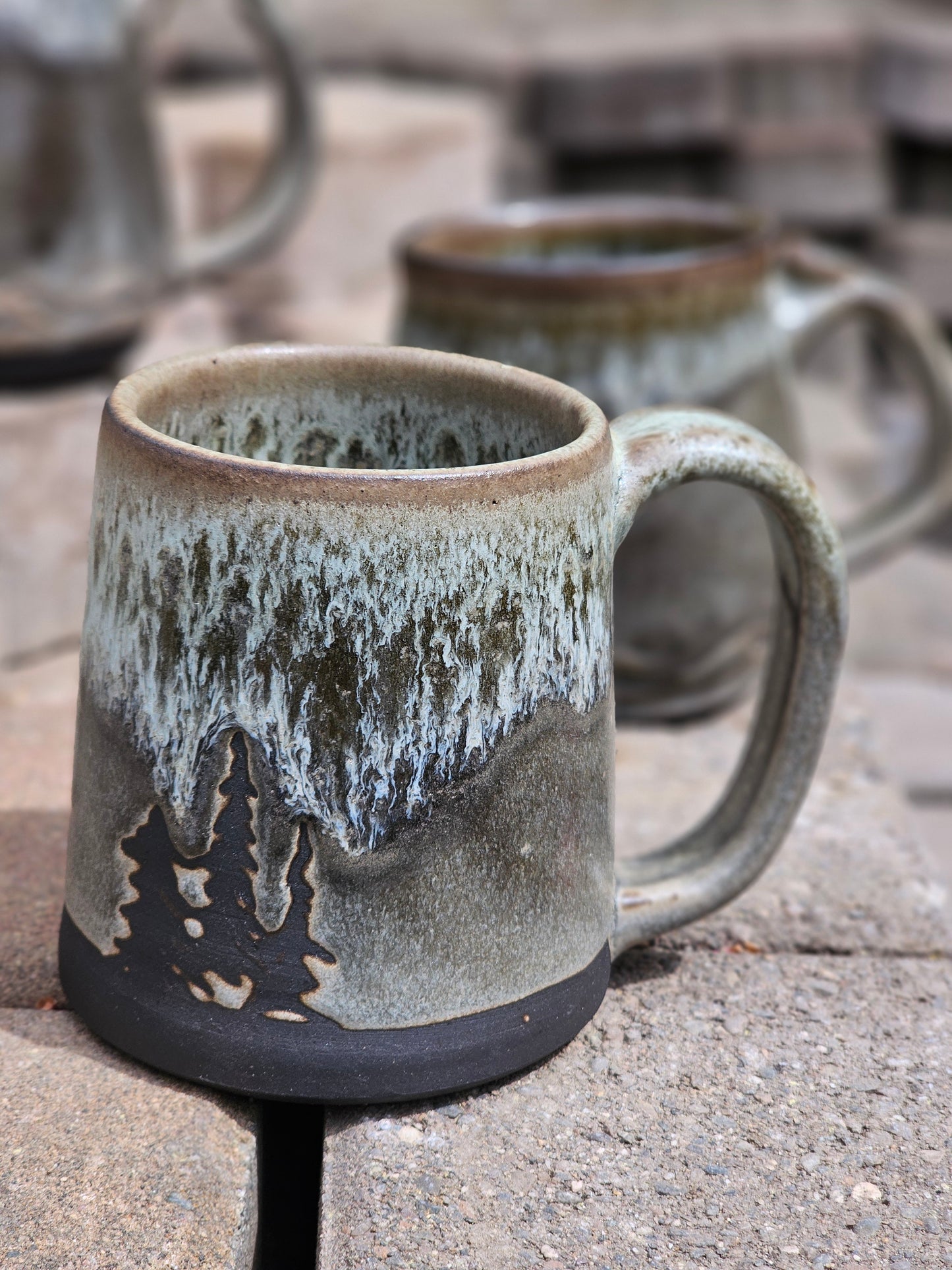 Handmade ceramic mug with textured surface and handle on a concrete surface
Details