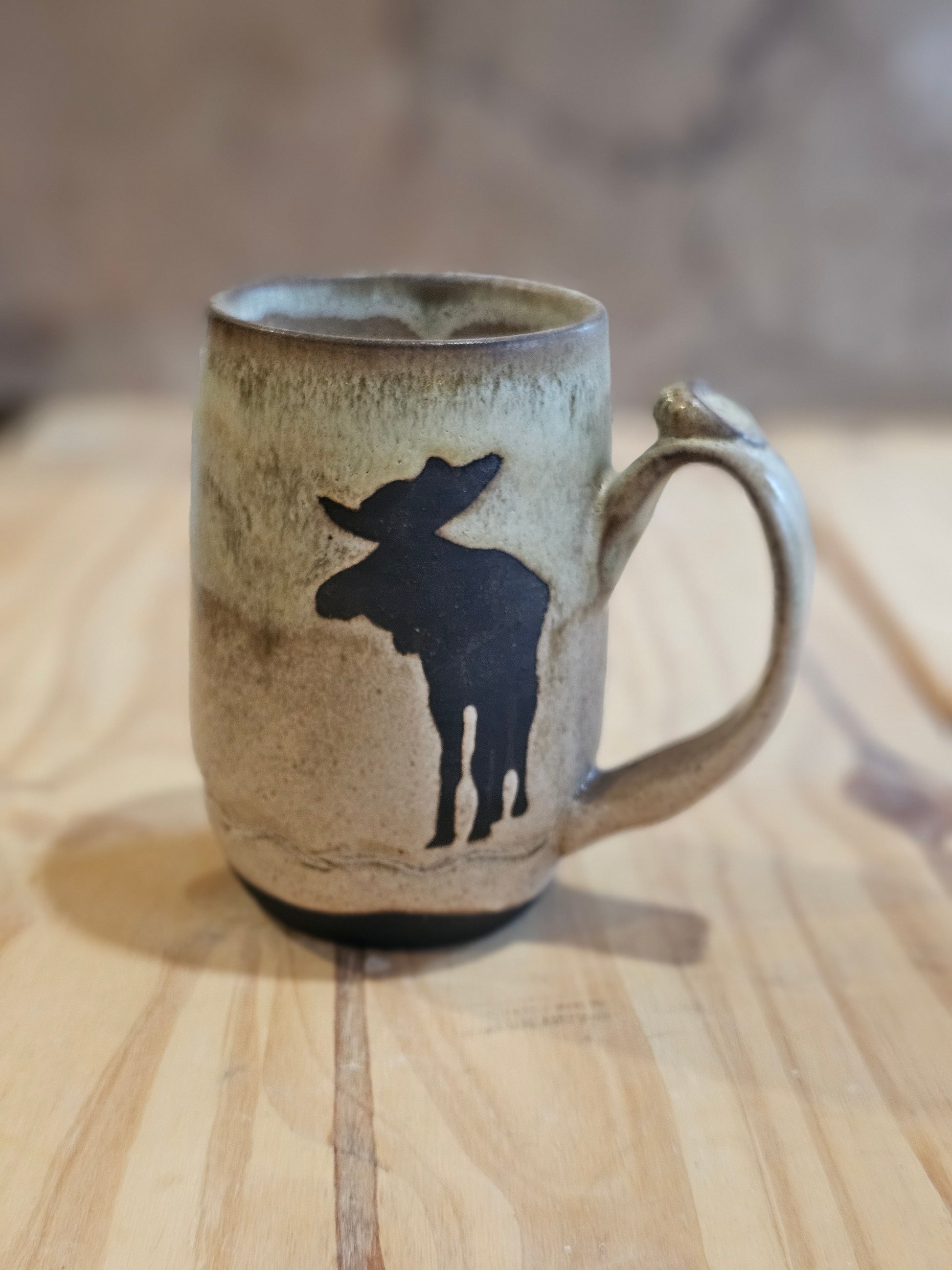 handmade ceramic mug with a moose on front  green over oatmeal glaze  northern Idaho