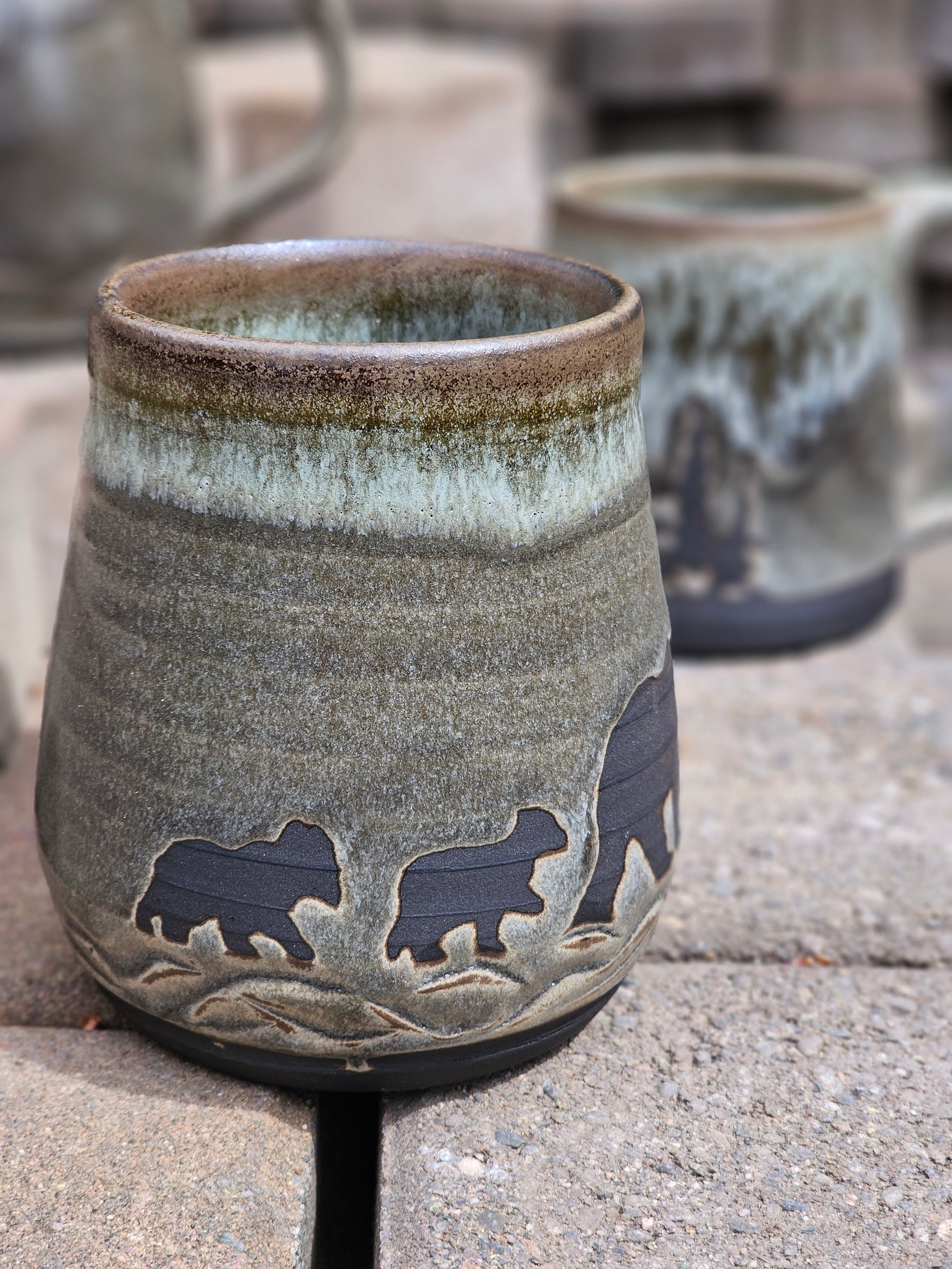 Ceramic cup with bear designs on a stone surface