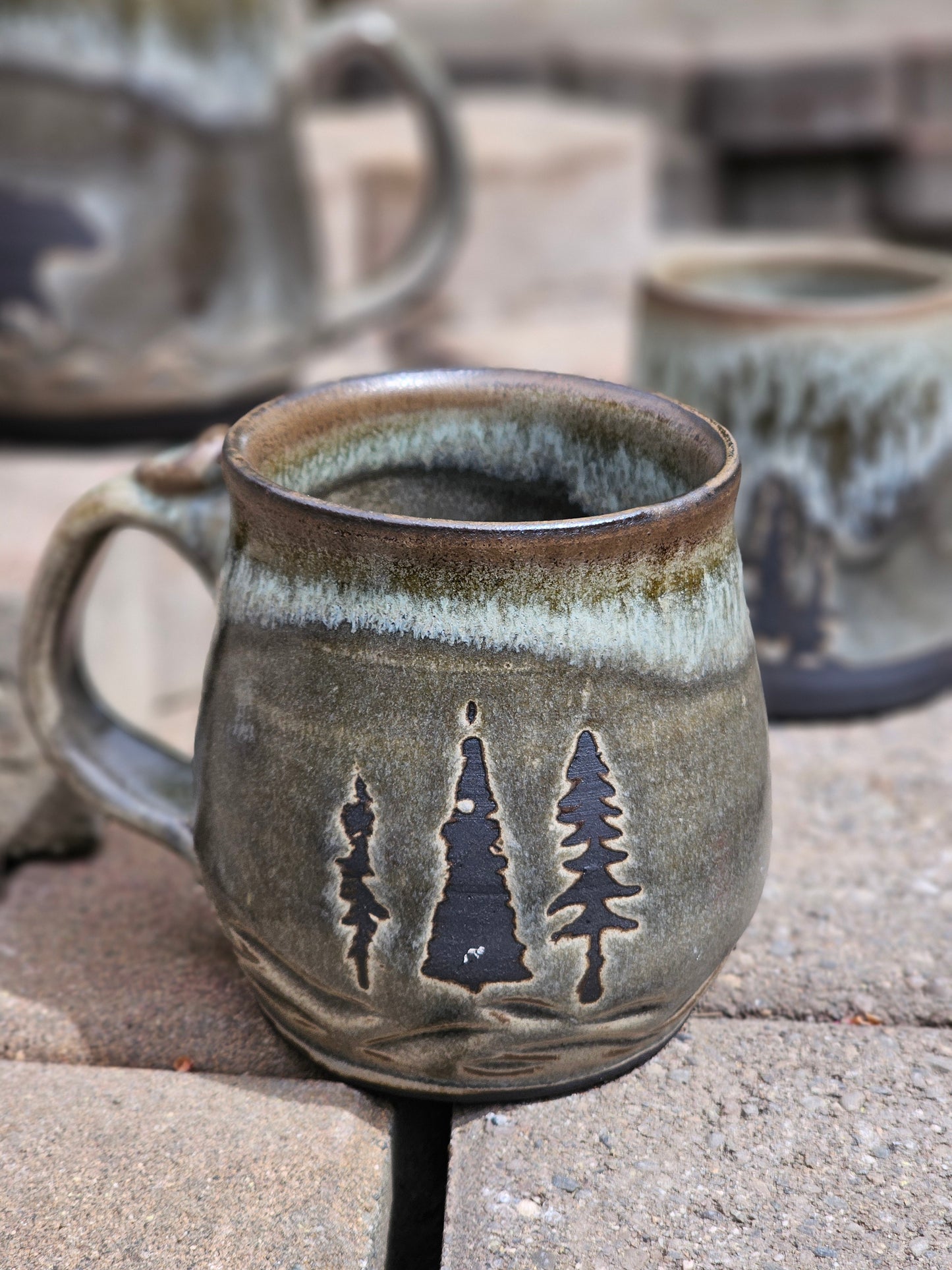 Ceramic mug with tree design on a stone surface