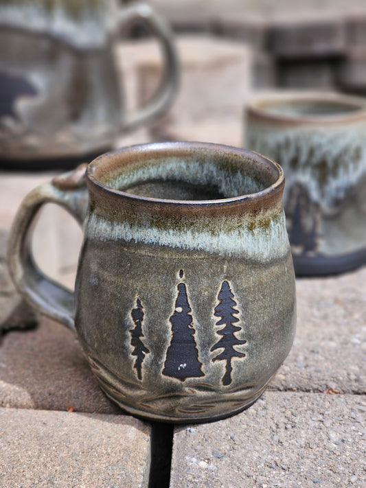 Ceramic mug with tree design on a stone surface