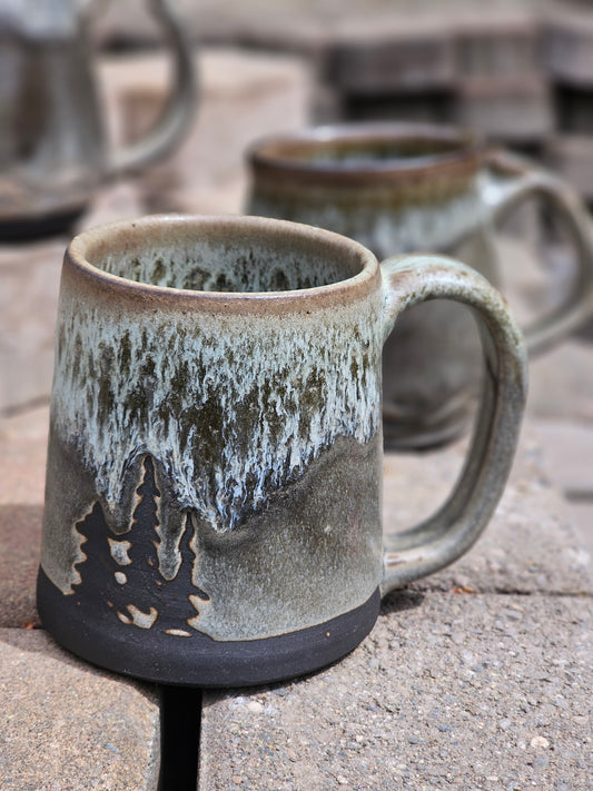 Handmade ceramic mug with textured surface and handle on a concrete surface
Details